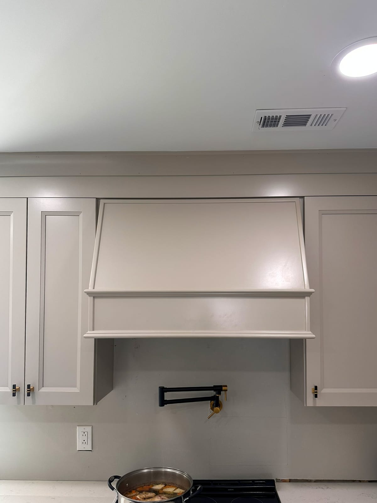 Kitchen remodel range wall with custom hood cabinet and upper cabinetry