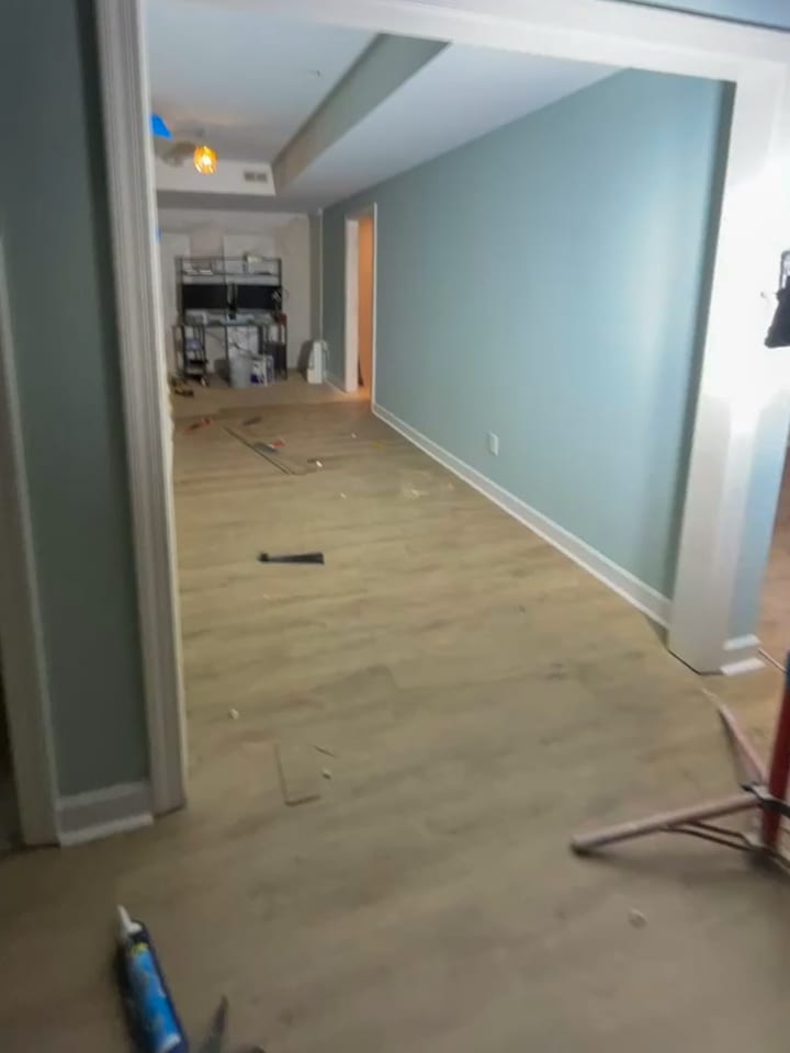 Living room remodel in progress with new flooring and painted walls