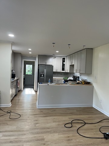 Kitchen remodel wide view with peninsula, gray cabinets, and open floor area